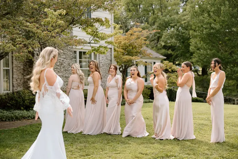 Her bridesmaids turning as she walks up