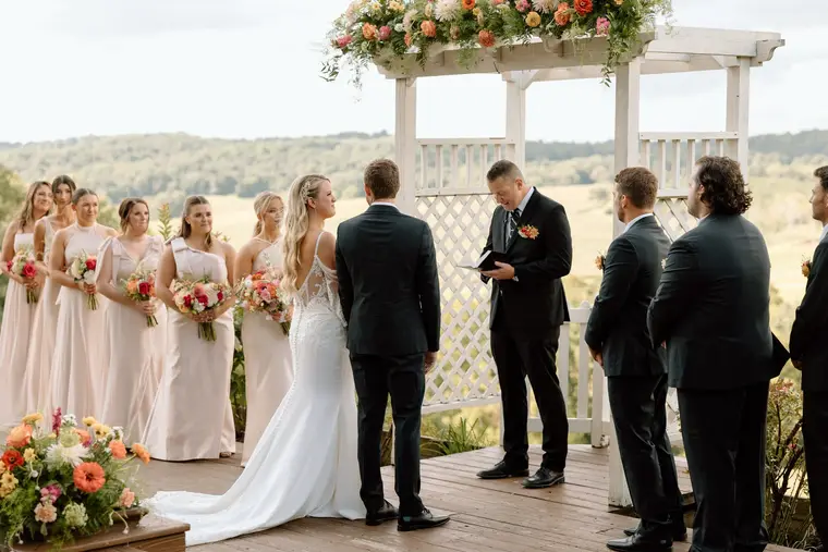 The vows under the arbor with the hills beyond