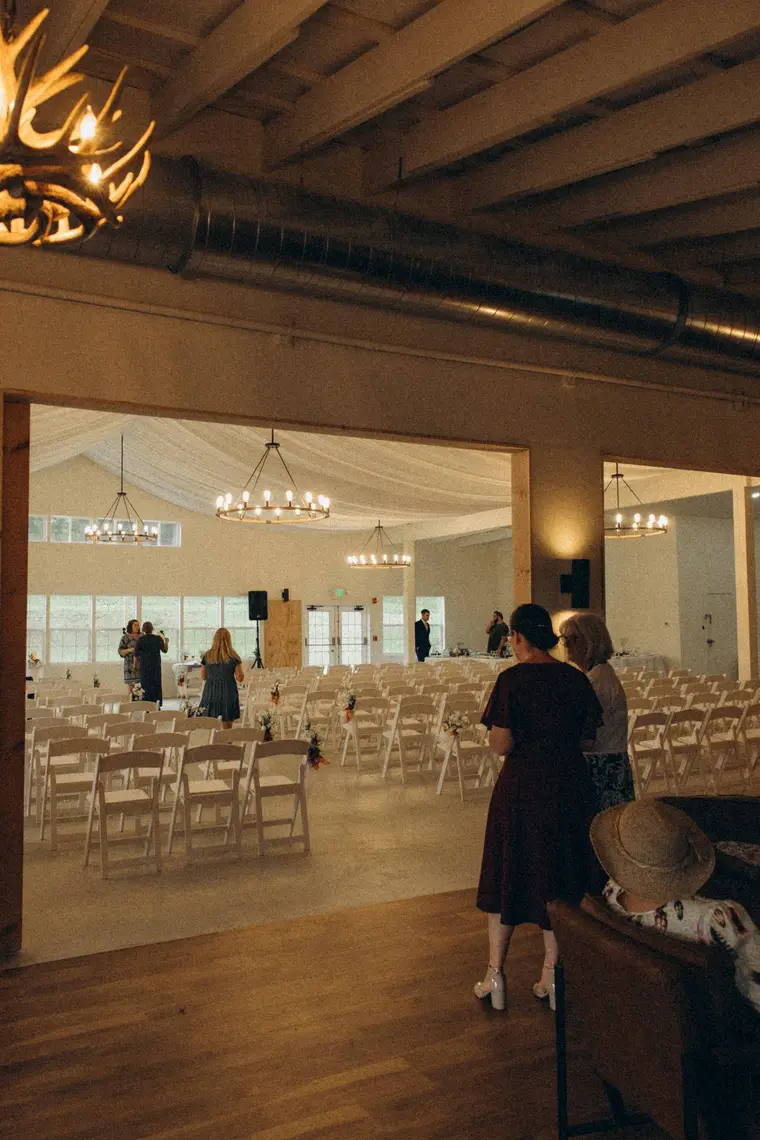 The barn set with white chairs beneath the rafters